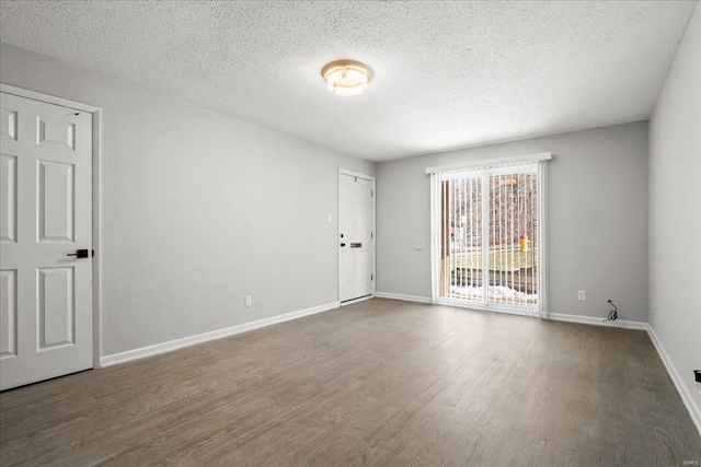 empty room with wood-type flooring and a textured ceiling