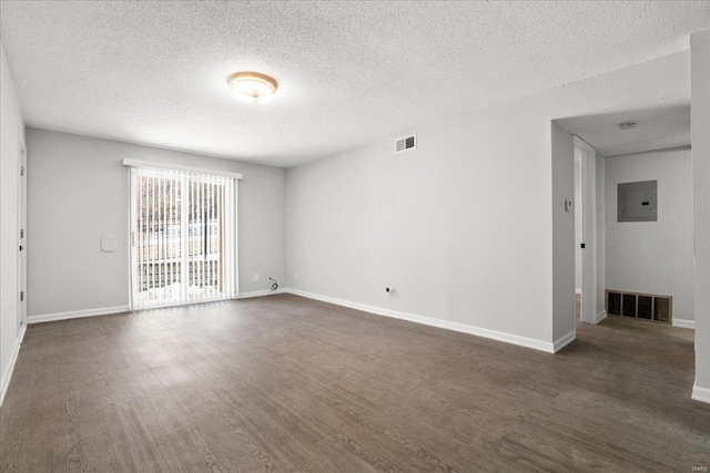 unfurnished room with dark hardwood / wood-style flooring, electric panel, and a textured ceiling