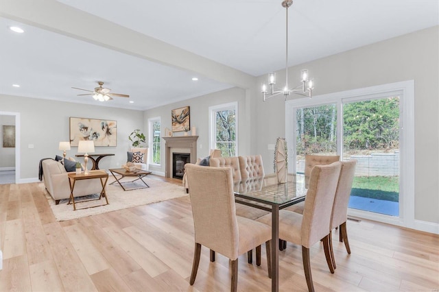 dining area featuring beamed ceiling, crown molding, ceiling fan with notable chandelier, and light wood-type flooring