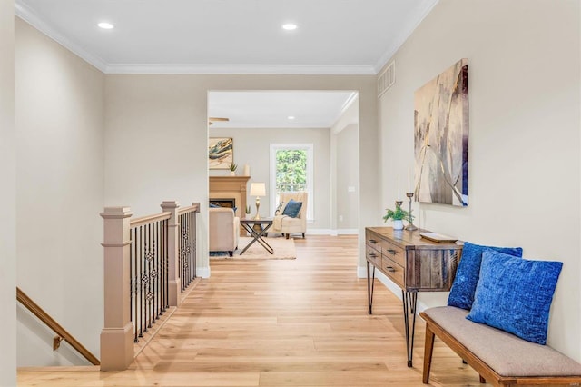 hallway with crown molding and light hardwood / wood-style flooring