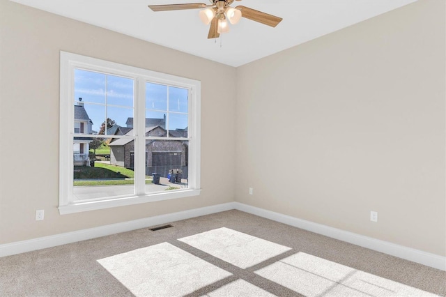 empty room with ceiling fan and light carpet