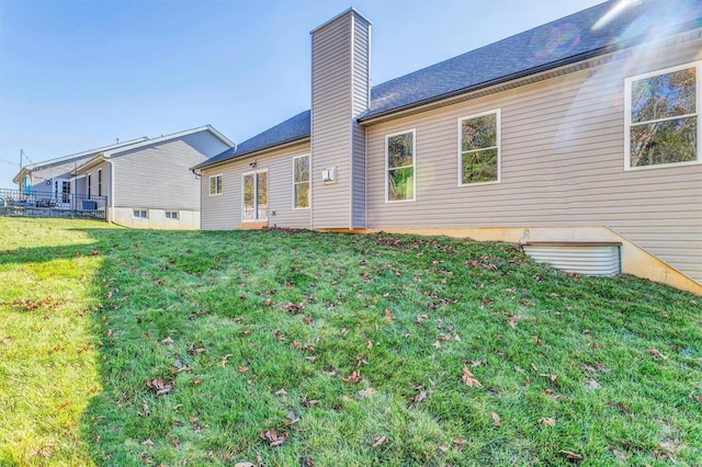 rear view of house featuring a yard