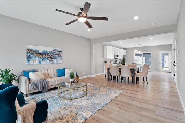 living room featuring ceiling fan and light wood-type flooring