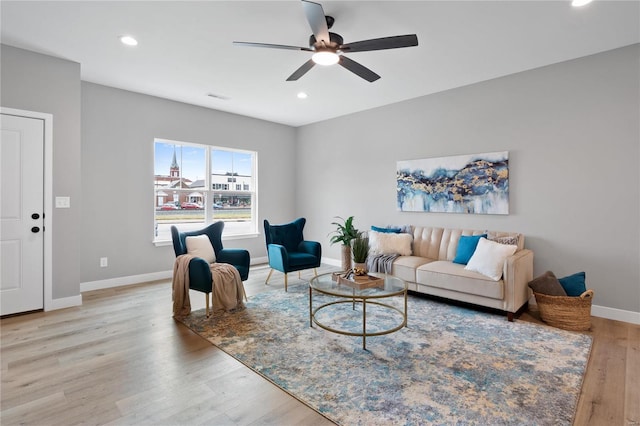 living room featuring ceiling fan and light hardwood / wood-style floors