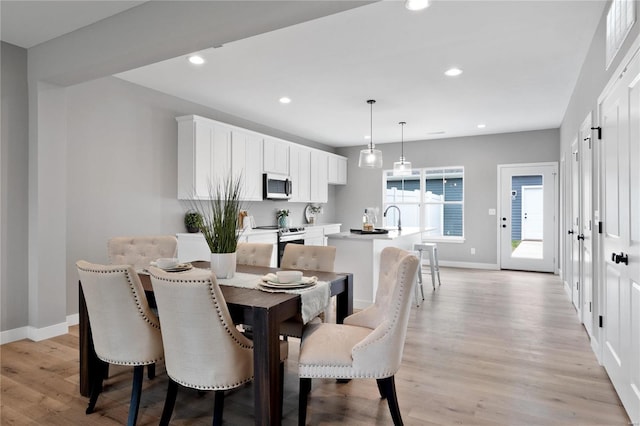 dining room featuring sink and light hardwood / wood-style floors