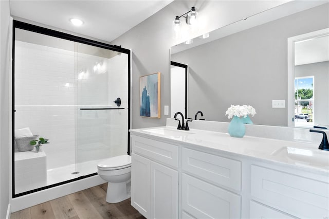 bathroom featuring vanity, toilet, an enclosed shower, and hardwood / wood-style floors