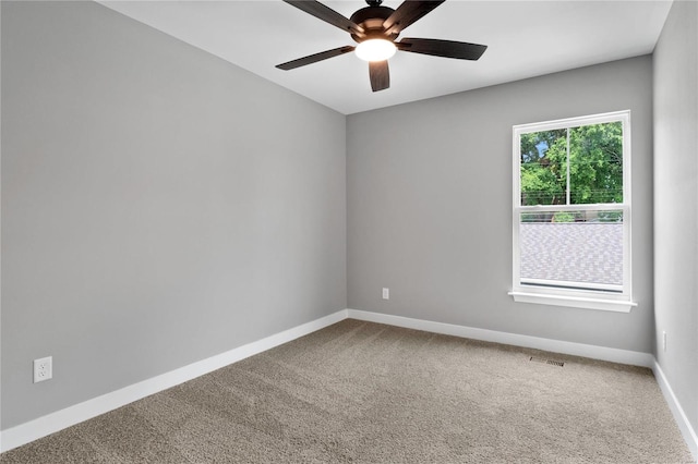 carpeted spare room featuring ceiling fan