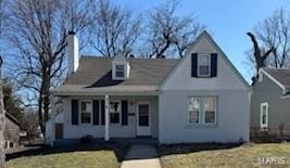 cape cod home with a front lawn