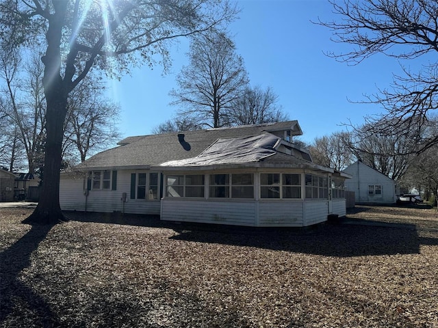 back of property with a sunroom