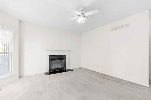 unfurnished living room featuring light colored carpet and ceiling fan