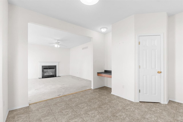 unfurnished living room featuring light colored carpet and ceiling fan