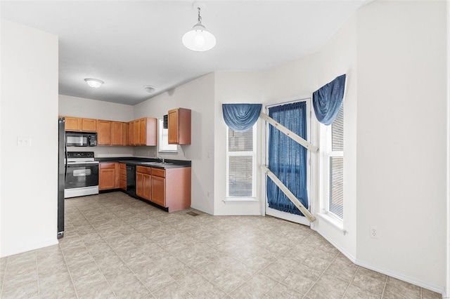 kitchen featuring sink, pendant lighting, and black appliances