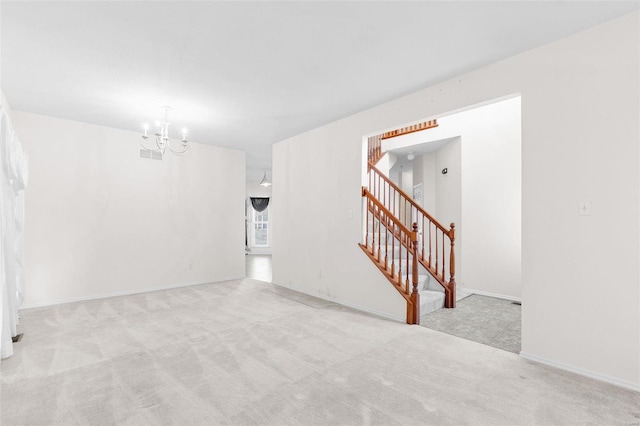 unfurnished room featuring light carpet and a chandelier