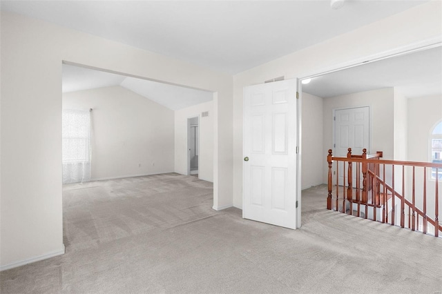 carpeted empty room with lofted ceiling