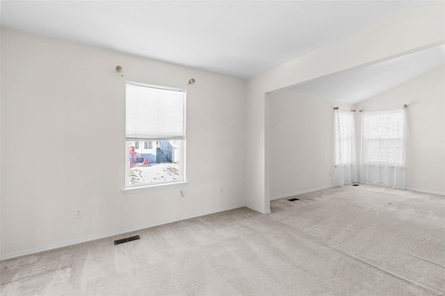 carpeted spare room featuring lofted ceiling