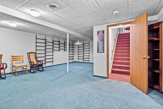 basement with a paneled ceiling and carpet flooring