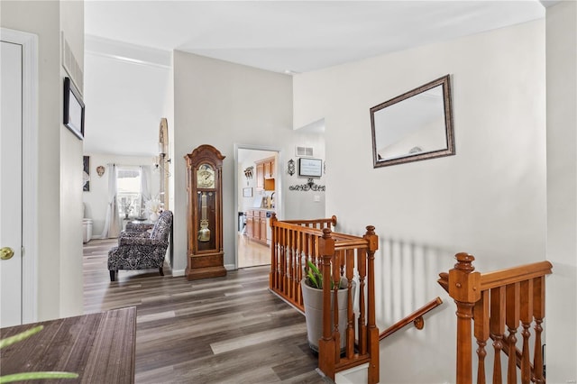 hall with lofted ceiling, visible vents, an upstairs landing, baseboards, and dark wood finished floors