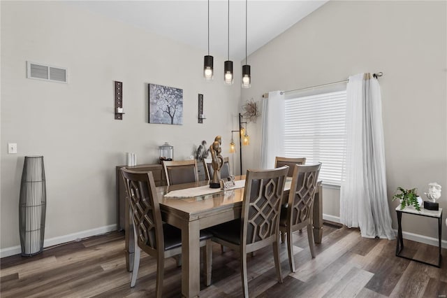 dining area with lofted ceiling, baseboards, visible vents, and dark wood-style flooring