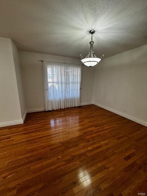 empty room featuring dark hardwood / wood-style floors and a textured ceiling