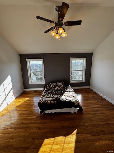 bedroom with multiple windows, lofted ceiling, dark wood-type flooring, and ceiling fan