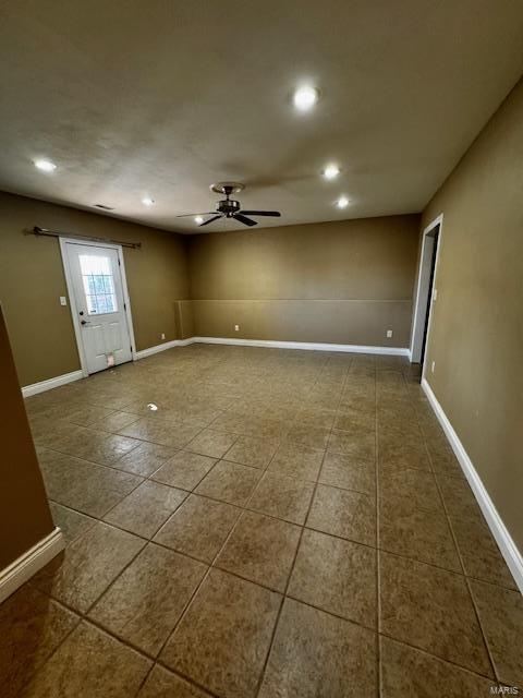 interior space featuring dark tile patterned flooring and ceiling fan