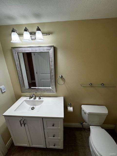 bathroom featuring vanity, tile patterned flooring, a textured ceiling, and toilet