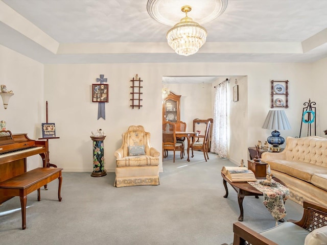 carpeted living room with an inviting chandelier and a tray ceiling