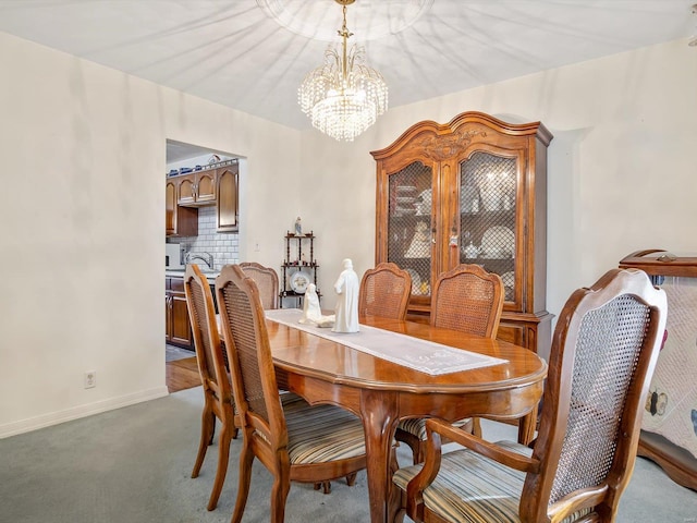 dining area with carpet flooring and an inviting chandelier