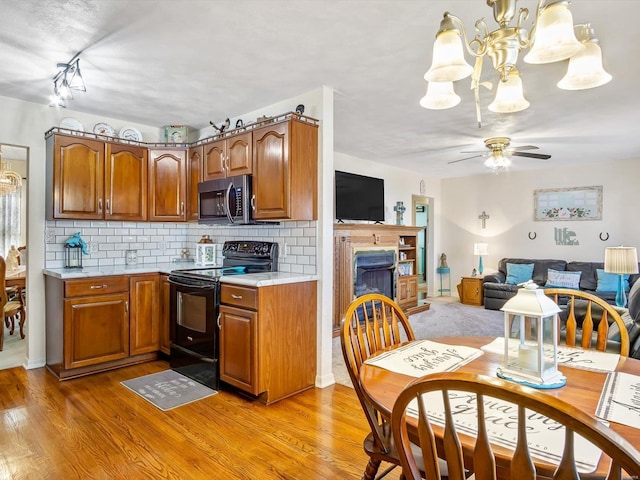 kitchen featuring black / electric stove, ceiling fan, decorative backsplash, and light hardwood / wood-style flooring