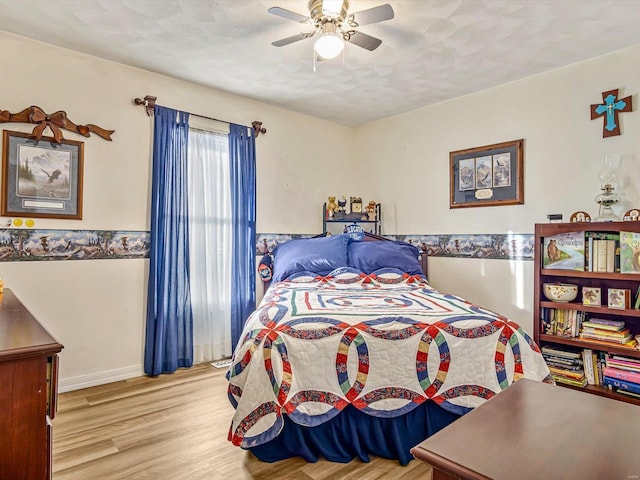 bedroom with a textured ceiling, ceiling fan, and light wood-type flooring