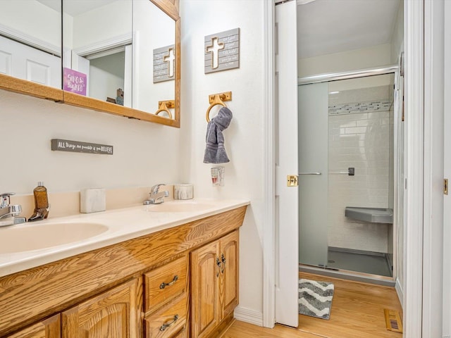 bathroom featuring vanity, hardwood / wood-style floors, and a shower with shower door