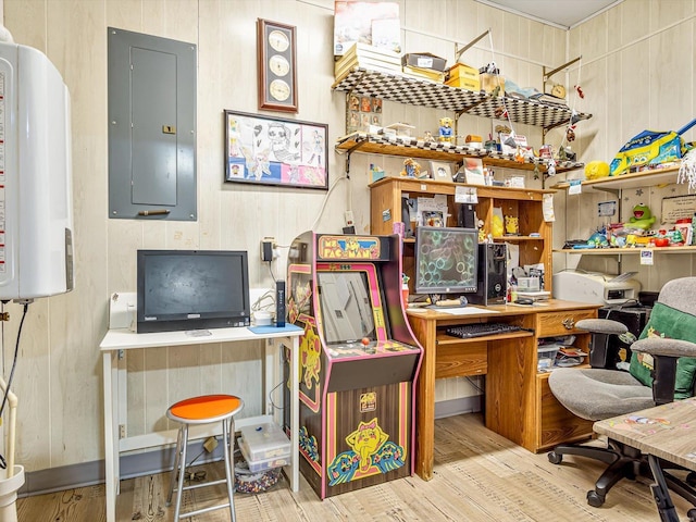 home office with light hardwood / wood-style flooring, wooden walls, electric panel, a workshop area, and water heater