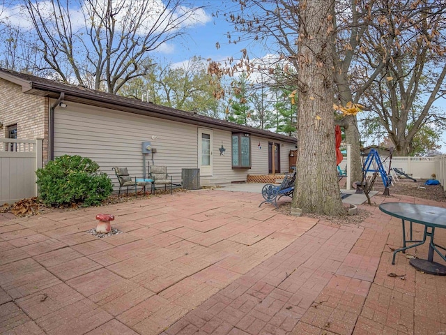 rear view of house with central air condition unit and a patio area