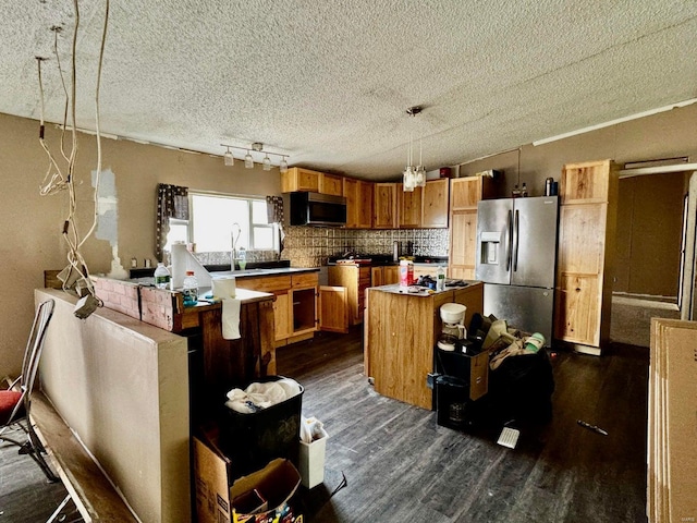 kitchen featuring sink, stainless steel appliances, a kitchen island, dark hardwood / wood-style flooring, and decorative light fixtures