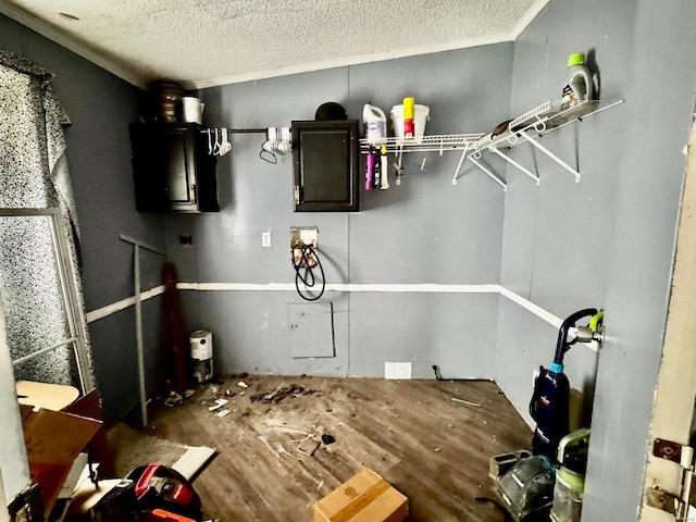 interior space featuring washer hookup, crown molding, and a textured ceiling