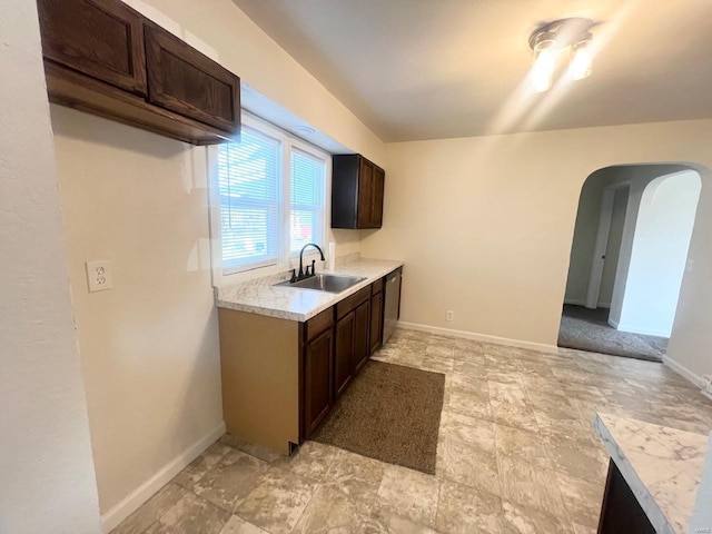 kitchen with sink, dark brown cabinets, and dishwasher