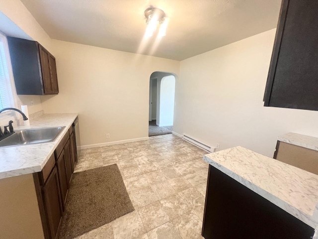 kitchen with dark brown cabinetry, sink, and a baseboard heating unit