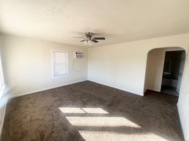 unfurnished room featuring dark colored carpet, a wall mounted air conditioner, ceiling fan, and a textured ceiling