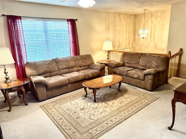 carpeted living room with a chandelier and a textured ceiling