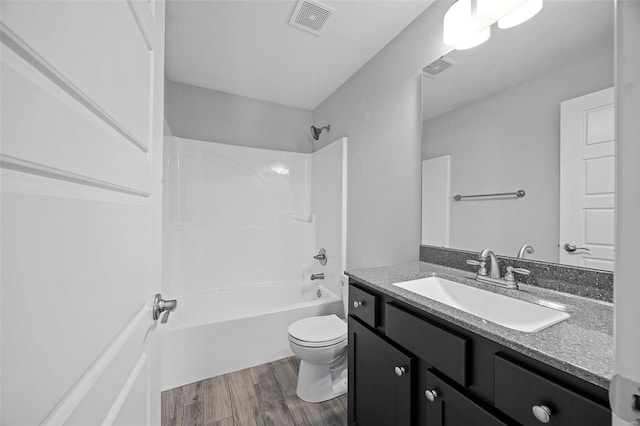 bathroom with visible vents, toilet, wood finished floors, tub / shower combination, and vanity