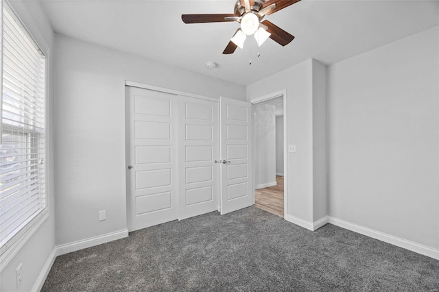 unfurnished bedroom featuring ceiling fan, a closet, carpet, and baseboards