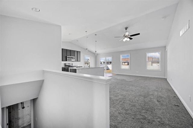 kitchen with carpet, stainless steel appliances, a ceiling fan, vaulted ceiling, and a sink