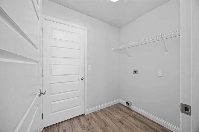 clothes washing area featuring laundry area, wood finished floors, electric dryer hookup, and baseboards