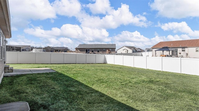 view of yard featuring a residential view, a fenced backyard, and a patio