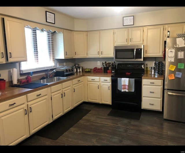 kitchen featuring appliances with stainless steel finishes, dark hardwood / wood-style flooring, and sink