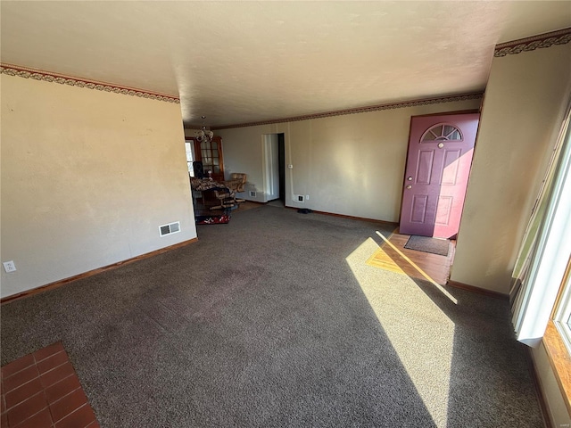 carpeted entryway featuring ornamental molding and a notable chandelier