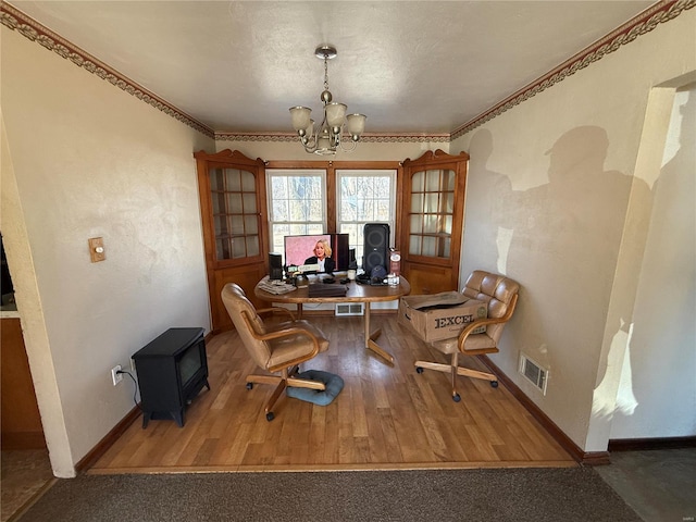 sitting room with hardwood / wood-style flooring, ornamental molding, and an inviting chandelier