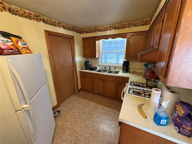 kitchen with sink, range, and white fridge