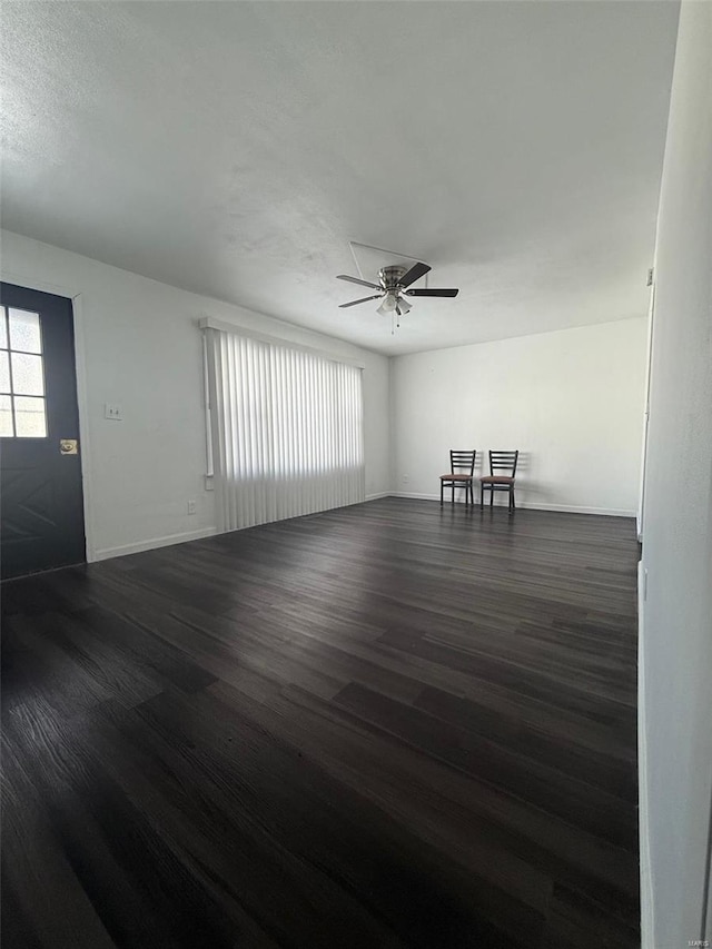 unfurnished room with dark wood-type flooring and ceiling fan