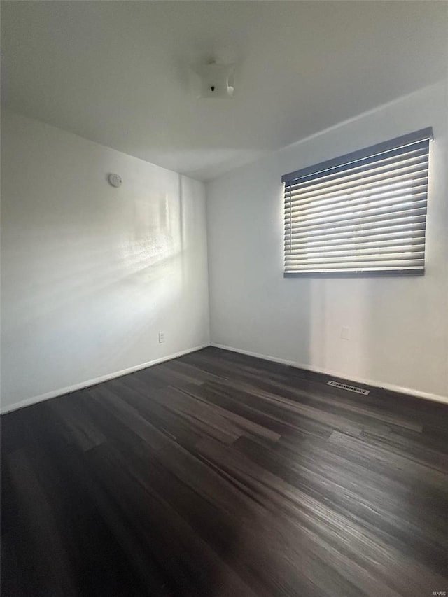 unfurnished room with dark hardwood / wood-style flooring